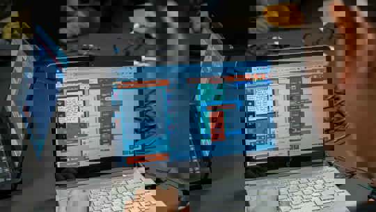 Person programmiert Spiel am Laptop