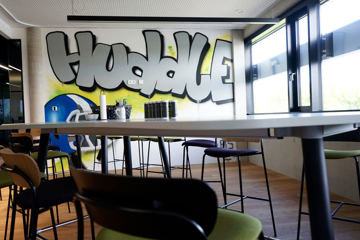 Das Huddle-Graffiti ziert den Aufenthaltsbereich im 3. Stock der Zentrale in Hagenberg.