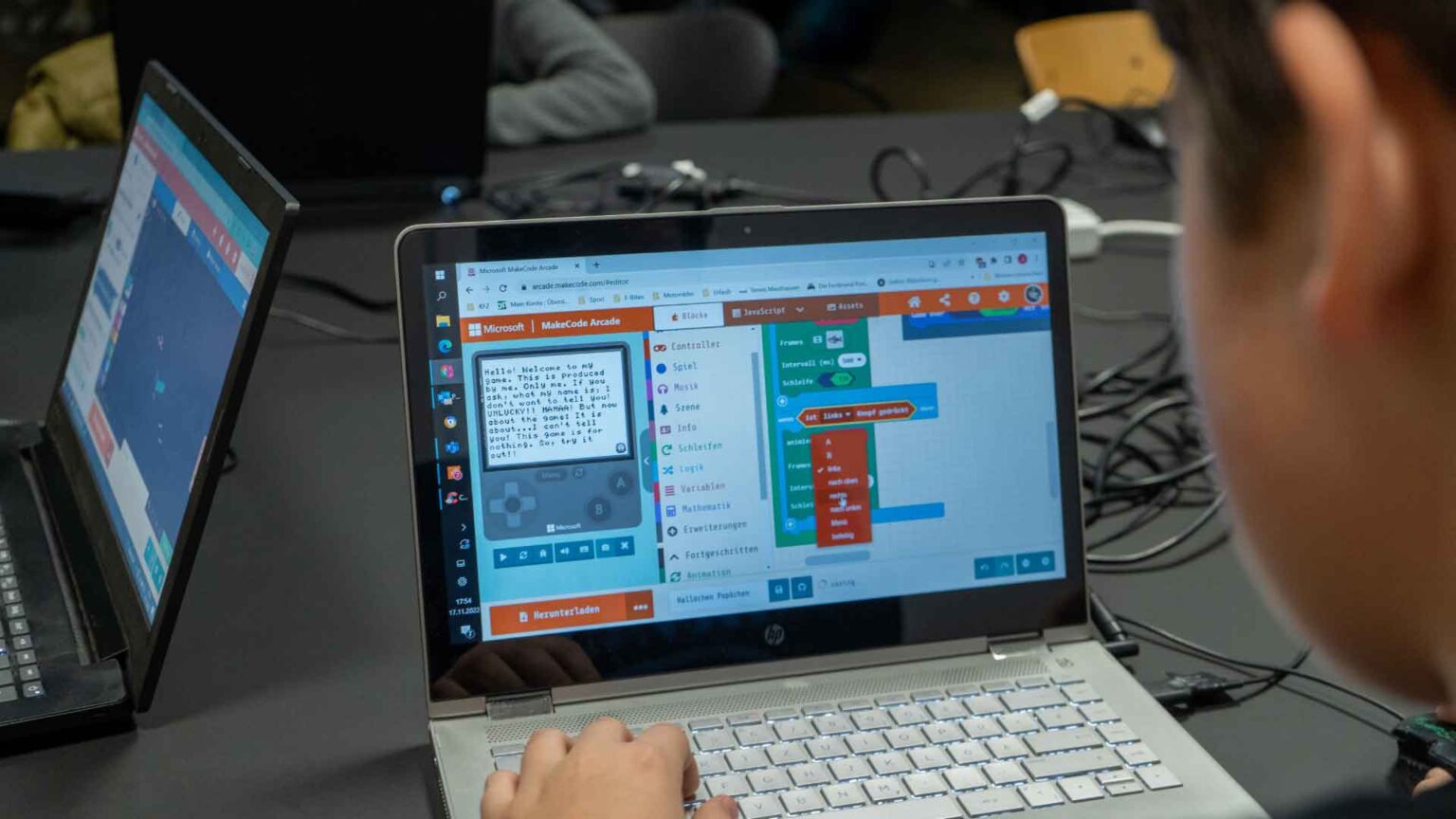 Person programmiert Spiel am Laptop - Digital Dojo