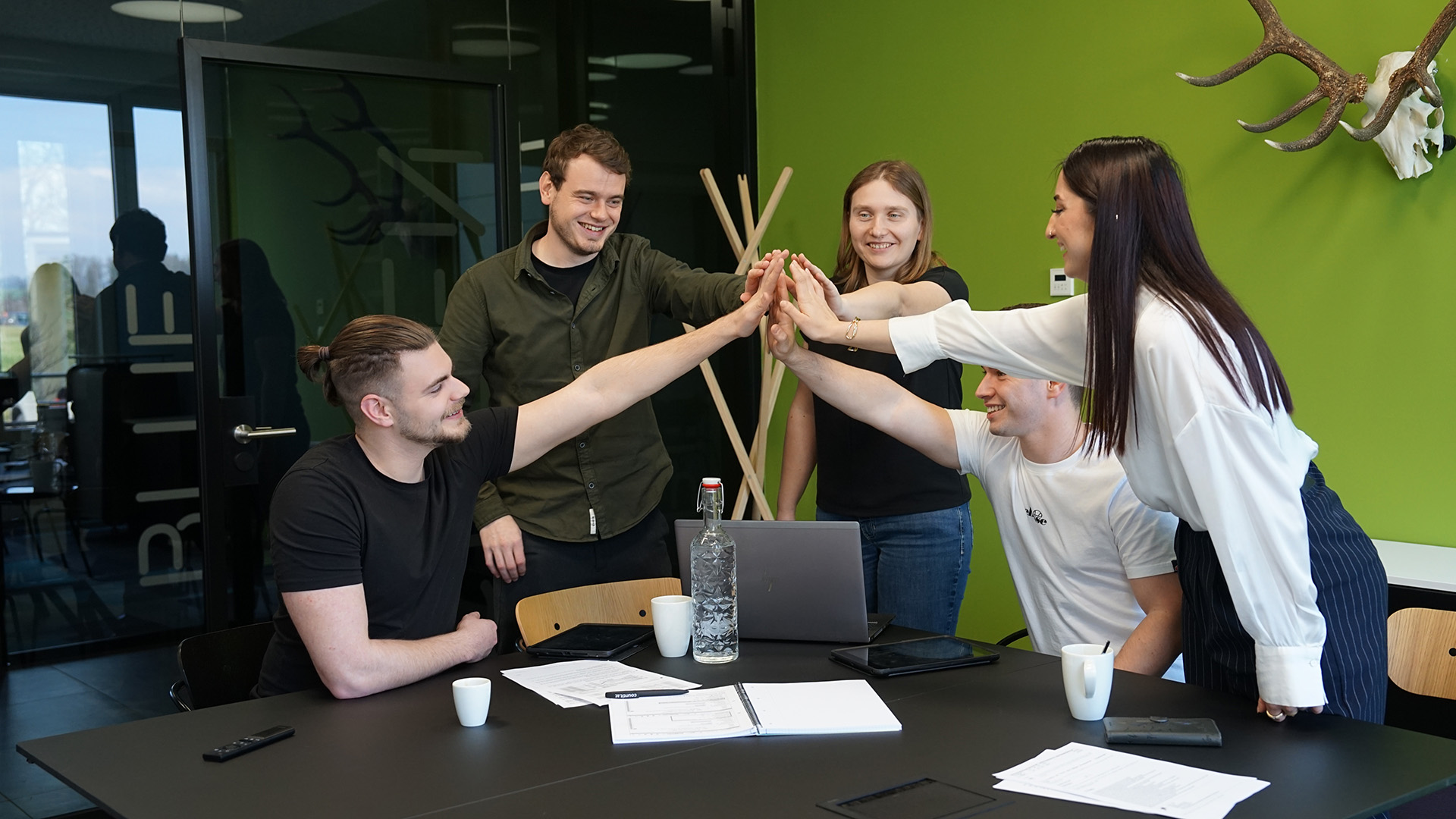 Vier Personen geben sich ein Highfive