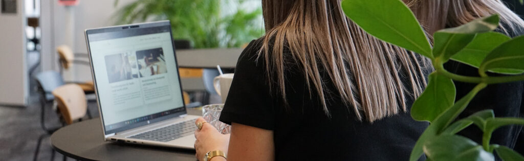 Lehre Medienfachmann/frau mit Schwerpunkt online Marketing, Frau mit Rücken zugewandt arbeitet auf Laptop